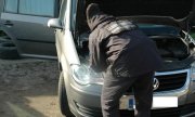 Technik kryminalistyki robi oględziny samochodu