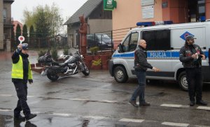 policjant zatrzymuje pojazd w tle radiowóz i 2 motocyklistów