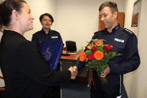 Pracownica banku otrzymuje kwiaty i pamiątkową tabliczkę