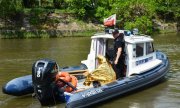 policjanci na łodzi służbowej przewożą uratowanego mężczyznę w folii NRC