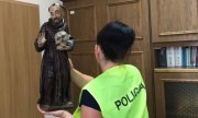 policjantka trzyma odzyskaną rzeźbę Św. Franciszka