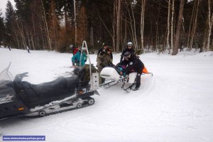 policjanci i ratownicy pomagają młodej narciarce