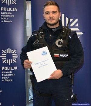 Nagrodzony policjant prezentuje list gratulacyjny