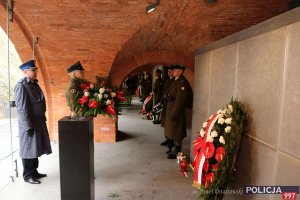 Zastępca KGP mł. insp. Tomasz Szymański składa wieniec pod tablicą pamięci podczas uroczystości Dnia Pamięci Ofiar Zbrodni Katyńskiej