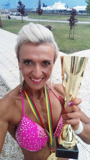 policjantka z Łasku złotą medalistką Mistrzostw Europy w kulturystyce i fitness w stroju bikini trzymająca zwycięski puchar