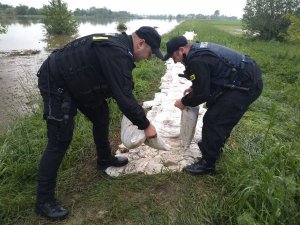 siły  Oddziałów Prewencji Policji w Krakowie, których funkcjonariusze, na prośbę lokalnej ludności pomagają w zabezpieczaniu domów i wałów