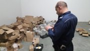 umundurowany policjant podczas czynności zabezpieczenia podrobionych perfum