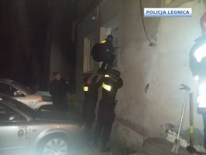 Policjanci próbują wejść do mieszkania przez okno