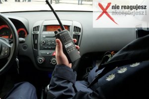 policjant w radiowozie trzyma krótkofalówkę