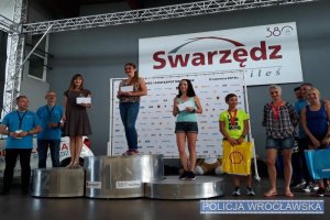 Nadkom. Joanna Woźniak-Cieślar z wrocławskiej Policji na podium zawodów, wspólnie z uczestnikami zawodów
