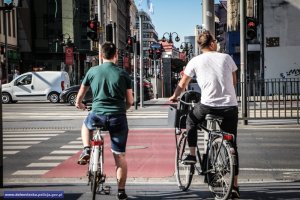 Mężczyźni na rowerach czekający na drodze dla rowerzystów na zmianę świateł