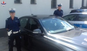 sierż. szt. Aldona Bartosiewicz i st. sierż. Maciej Zdunek stoją przy radiowozie policyjnym