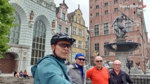 czterej policjanci w strojach sportowych  w Gdańsku przy pomniku Neptuna