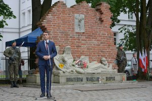 Rzecznik rządu Piotr Muler w trakcie przemowy pod pomnikiem.
