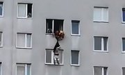 Zdjęcie przedstawia mężczyznę, który chciał popełnić samobójstwo skacząc z parapetu oraz akcję służb ratowniczych