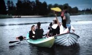 dwie łódki, na których znajduje się grupa młodzieży pijąca alkohol