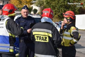 policjant i trzech strażaków ustalających kolejność działań podczas akcji ratowniczej