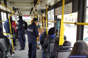 Policjanci rozdają ulotki informacyjne w tramwaju