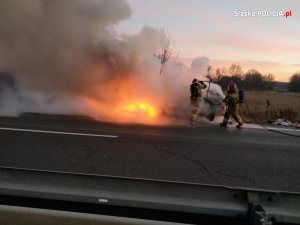 Strażacy gaszący palący się samochód