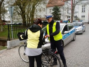 Starszy sierżant Krzysztof Pawłat pomaga rowerzystce