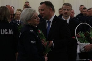 Prezydent Andrzej Duda wręcza kwiaty policjantce