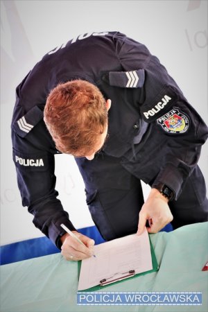 Policjant podpisuje dokumenty