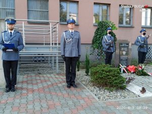 Policjanci przed tablicą pamiątkową sierż. Grzegorza Załogi