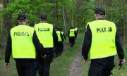 grupa policjantów w trakcie poszukiwań mężczyzny w lesie