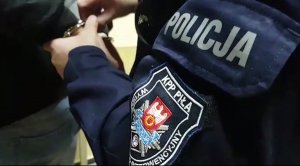 policjant zakłada kajdanki zatrzymanemu mężczyźnie
