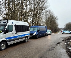Policyjny radiowóz, za nim niebieski bus i samochód Straży Granicznej