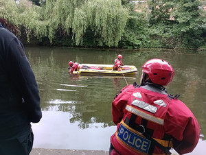 policjanci na łodzi przeszukujący dno rzeki