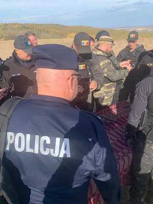 Policjant i grupa mołdawskich funkcjonariuszy w trakcie szkolenia.
