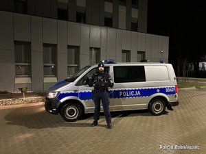 umundurowany policjant stoi przy radiowozie
