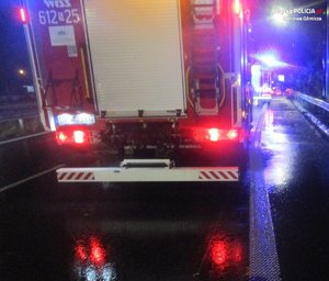 Tył pojazdu straży pożarnej zabezpieczający miejsce wypadku. w tle niebieskie lampy błyskowe pojazdów uprzywilejowanych