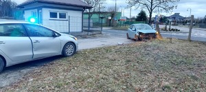 Miejsce zdarzenia, nieoznakowany radiowóz i rozbity samochód osobowy na ogrodzeniu posesji.