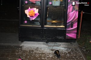 zdjęcie-noc, wybita szyba w automacie z kwiatami, pusta półka