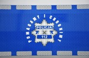 Policyjna gwiazda na radiowozie, a wokół niej napis: Pomagamy i chronimy