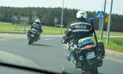 dwa policyjne motocykle. policjanci jadą na rondzie