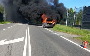 płonący samochód przy drodze
