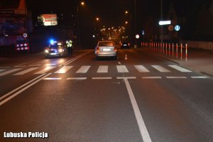 Radiowóz i samochód osobowy na miejscu zdarzenia drogowego w porze nocnej