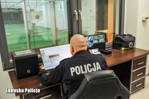 Policjant przy biurku i komputerze