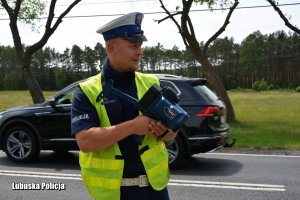 Policjant ruchu drogowego szykujący się do mierzenia prędkości pojazdów