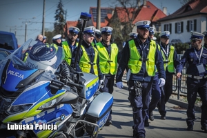 policyjny motocykl i idący mundurowi