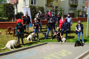 wspólne zdjęcie, na którym stoją między innymi  policjanci i przewodnicy psów