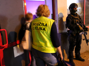 Funkcjonariusze Warmińsko-Mazurskiego Urzędu Celno-Skarbowego przed wejściem do jednego z budynków z nielegalnymi automatami