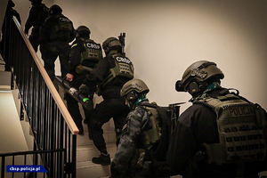 policjanci CBŚP idący klatką schodową, ubrani na bojowo