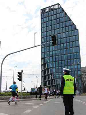 na zdjeciu widac stojąca policjantke na tle budynku baltyk