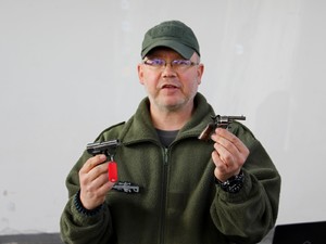 policjant balistyk prezentuje 2 pistolety kieszonkowe