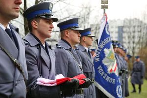 Fotografia kolorowa. Na zdjęciu widoczni policjanci ze sztandarem Komendy Wojewódzkiej Policji w Katowicach.