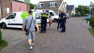 Polscy i holenderscy policjanci rozmawiają z Polakami pracującymi w Holandii podczas kontroli miejsc ich pracy i zamieszkania.